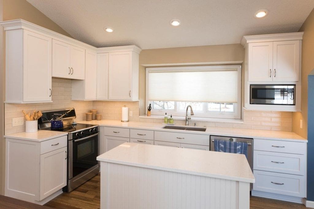 A kitchen with white cabinetsDescription automatically generated